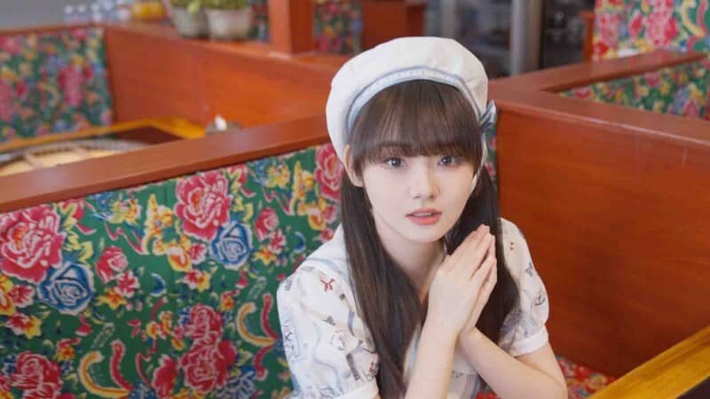 To Be Love With Girls Group - Nét đáng yêu của nhân vật trong một cảnh gameplay. Cận cảnh một nhân vật nữ dễ thương với mái tóc nâu và chiếc mũ beret trắng trong một cảnh quay gameplay của To Be Love With Girls Group.