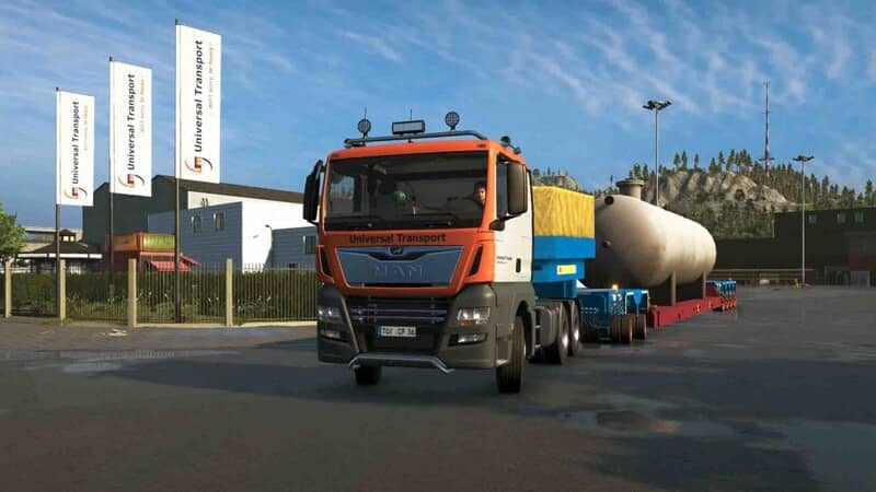 Khám phá thế giới Heavy Cargo: chiếc xe tải màu cam đang đậu trong một khu công nghiệp rộng lớn, chuẩn bị bốc dỡ một bồn chứa nhiên liệu khổng lồ. Xung quanh là các nhà kho, cần cẩu và nhiều chi tiết mô phỏng một khu vực hậu cần nhộn nhịp.