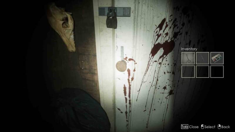 "Một cảnh gameplay kinh dị trong Slackjaw" "Ảnh gameplay game Slackjaw, góc nhìn thứ nhất, nhân vật đang đứng trước một cánh cửa dính đầy máu. Giao diện trò chơi hiển thị kho đồ với nhiều vật phẩm khác nhau."