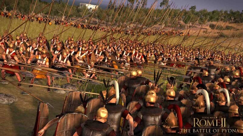 Ảnh gameplay Total War Rome II, một đạo quân La Mã khổng lồ đang dàn trận trên chiến trường. Hàng vạn binh sĩ La Mã với giáp sắt và khiên đỏ đang chuẩn bị chiến đấu, khung cảnh rộng lớn và hoành tráng.