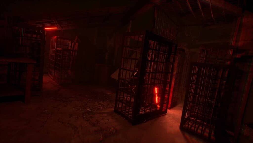 Căn phòng tối với nhiều lồng sắt giam giữ, ánh đèn đỏ rực trong TORMENTOR