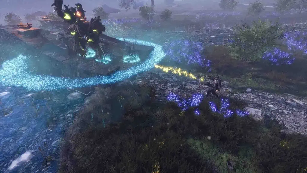 Một góc nhìn gameplay khác của "Ash & Rust", tập trung vào lối chơi lén lút và phép thuật. Nhân vật mặc áo choàng sẫm màu đang nép mình sau bụi cây có hoa xanh, sử dụng kỹ năng phép thuật tạo ra dòng năng lượng màu vàng tấn công một kẻ thù hoặc vật thể phía xa. Phía trước kẻ thù là một vòng tròn phép thuật màu xanh lục. Bối cảnh là một vùng đất hoang sơ, ẩm ướt với tàn tích đá và nhiều cây bụi.